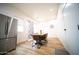 Dining area featuring a modern table with chairs, stainless steel refrigerator, and a contemporary light fixture at 2441 W Morten Ave, Phoenix, AZ 85021