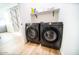 Laundry room with washer, dryer, shelving, and wood-look flooring at 2441 W Morten Ave, Phoenix, AZ 85021