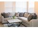 Bright living room features a comfortable sectional sofa, decorative pillows, and a stylish marble coffee table at 2441 W Morten Ave, Phoenix, AZ 85021