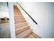 Modern staircase features light wood steps with a dark metal handrail, and white risers at 2441 W Morten Ave, Phoenix, AZ 85021