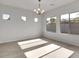 Sunlit dining room with large windows, neutral colors, and a modern chandelier at 2524 N Pony Ln, Casa Grande, AZ 85122