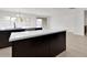 Kitchen island with white countertops, dark cabinets, with views of the outdoor space at 2524 N Pony Ln, Casa Grande, AZ 85122