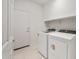 Bright laundry room with white appliances, neutral tile flooring, and convenient shelving at 2649 N Riverside Dr, Florence, AZ 85132