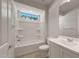 Well-lit bathroom with a shower-tub combo and window view at 26957 W Lone Cactus Dr, Buckeye, AZ 85396