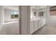 Bathroom featuring a double sink vanity with modern fixtures, white cabinets, and a view to a bedroom at 26957 W Lone Cactus Dr, Buckeye, AZ 85396