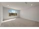 Bright bedroom with large window offering a view of the outdoors and neutral carpeting at 26957 W Lone Cactus Dr, Buckeye, AZ 85396