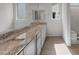 Bathroom showcasing dual sinks, granite countertops and stylish tile flooring, filled with natural light at 26973 W Lone Cactus Dr, Buckeye, AZ 85396