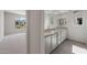 Bathroom featuring double sinks, granite countertop and tile flooring, located next to bedroom at 26973 W Lone Cactus Dr, Buckeye, AZ 85396