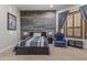 A bedroom featuring a rustic wood accent wall, queen bed, and a blue chair at 27582 N 67Th Way, Scottsdale, AZ 85266