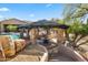 View of an outdoor cabana area with stone pillars, a barbecue, and nearby pool at 27582 N 67Th Way, Scottsdale, AZ 85266