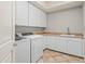 Well-lit laundry room with white cabinets, tan countertops, and washer and dryer at 27582 N 67Th Way, Scottsdale, AZ 85266