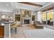 Elegant living room with tiled floors, a stone fireplace, and access to an outdoor patio at 27582 N 67Th Way, Scottsdale, AZ 85266