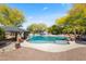 An inviting pool with a rock waterfall feature and a shaded seating area at 27582 N 67Th Way, Scottsdale, AZ 85266