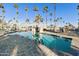 Resort-style pool featuring palm trees and an artificial rock structure for a tranquil and luxurious experience at 2929 E Main St # 135, Mesa, AZ 85213