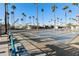 A shuffleboard court with benches, surrounded by tall palms and blue skies, perfect for recreation at 2929 E Main St # 135, Mesa, AZ 85213