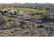 An aerial view of a desert neighborhood with a golf course in the background and desert landscaping at 3109 W Summit Walk Ct, Anthem, AZ 85086