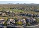 An aerial view of a desert neighborhood near a green golf course with mountain views in the background at 3109 W Summit Walk Ct, Anthem, AZ 85086