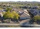 Drone shot of a property with desert landscaping, a three car garage, and a tile roof at 3109 W Summit Walk Ct, Anthem, AZ 85086