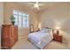 Cozy bedroom featuring a ceiling fan, shuttered window, and traditional furnishings at 3109 W Summit Walk Ct, Anthem, AZ 85086