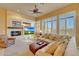 Cozy living room with a stone fireplace, built-in entertainment center, and plantation shutters at 3109 W Summit Walk Ct, Anthem, AZ 85086