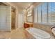 Bright and airy main bathroom with soaking tub, walk-in shower and tiled walls at 3109 W Summit Walk Ct, Anthem, AZ 85086