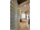 Main bath with glass block partition, soaking tub, and travertine tile floors at 3109 W Summit Walk Ct, Anthem, AZ 85086