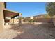 Backyard with small palm trees, rock landscaping, and covered patio at 3111 W Pleasant Ln, Phoenix, AZ 85041