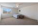 Comfortable carpeted bedroom with a bed, ottoman, and natural light from the window at 3111 W Pleasant Ln, Phoenix, AZ 85041