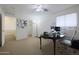 Well-lit carpeted bedroom with a ceiling fan and a workspace with a desk at 3111 W Pleasant Ln, Phoenix, AZ 85041