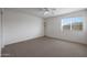 Bright, carpeted bedroom featuring a ceiling fan and a window with natural light at 3111 W Pleasant Ln, Phoenix, AZ 85041