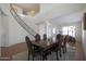 Open dining room with grand staircase, featuring neutral walls, a striking table, and a decorative rug at 3111 W Pleasant Ln, Phoenix, AZ 85041