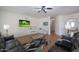 Relaxing living room featuring a sizable leather sofa, contemporary coffee tables, and a wall-mounted television at 3111 W Pleasant Ln, Phoenix, AZ 85041