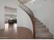 Elegant curved staircase with dark wood railing and carpeted steps, leading to an open living area at 3111 W Pleasant Ln, Phoenix, AZ 85041