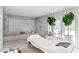 Luxurious bathroom featuring a spa bed, marble shower, freestanding tub, and stylish potted plants near the glass doors at 3702 E Camelback Rd, Phoenix, AZ 85018