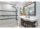 Modern bathroom with a glass-enclosed shower, vanity with a dark wood cabinet, and stylish shelving at 3702 E Camelback Rd, Phoenix, AZ 85018