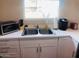 Well-lit kitchen with stainless steel sink, white cabinets, modern appliances, and quartz countertops at 4112 N 11Th St, Phoenix, AZ 85014