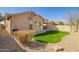 The backyard features green grass, desert landscaping, and an AC unit at 46072 W Barbara Ln, Maricopa, AZ 85139