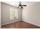 Empty bedroom featuring wood floors, a ceiling fan, a window, and neutral-colored walls at 46072 W Barbara Ln, Maricopa, AZ 85139