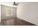 This bedroom features a ceiling fan, window with blinds, and wood-look flooring at 46072 W Barbara Ln, Maricopa, AZ 85139