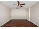 This bedroom features a ceiling fan, a door, and wood-look flooring at 46072 W Barbara Ln, Maricopa, AZ 85139