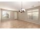 Bright living room with tile flooring, two windows, and modern chandelier at 46072 W Barbara Ln, Maricopa, AZ 85139