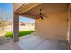 This covered patio has a ceiling fan and overlooks the lawn at 46072 W Barbara Ln, Maricopa, AZ 85139