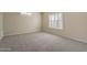 Neutral bedroom with beige walls, carpet, a window, and a small shelf at 5345 E Mclellan Rd # 83, Mesa, AZ 85205