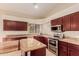 An open kitchen featuring granite countertops, cherry cabinets, a modern range and island at 5345 E Mclellan Rd # 83, Mesa, AZ 85205