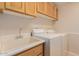 Functional laundry room with wooden cabinets and a utility sink at 5345 E Mclellan Rd # 83, Mesa, AZ 85205