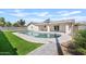 Beautiful backyard with a pool, manicured lawn, and covered patio at 5927 E Edgemont Ave, Scottsdale, AZ 85257