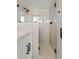 Modern bathroom with a glass-enclosed shower, white tile, and black hardware at 5927 E Edgemont Ave, Scottsdale, AZ 85257