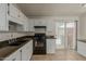 Well-lit kitchen featuring dark countertops, black appliances, and white cabinets with a view to the backyard at 6711 W Osborn Rd # 127, Phoenix, AZ 85033