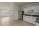 Efficient kitchen with stainless steel refrigerator, white cabinets, and a view into the well-lit living room at 6711 W Osborn Rd # 127, Phoenix, AZ 85033