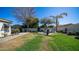 A grassy backyard space offers mature trees and a fireplace for outdoor enjoyment at 737 E Boston St, Gilbert, AZ 85295